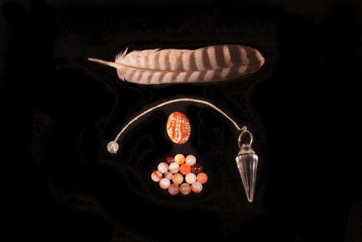 Feather, pendulum and gemstones, intuitive search